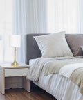 Tapered Fabric Drum Shade Table Lamp In Gold And White With Pull Chain Switch 8 By 8 By 21 Inches on bedside table in bedroom