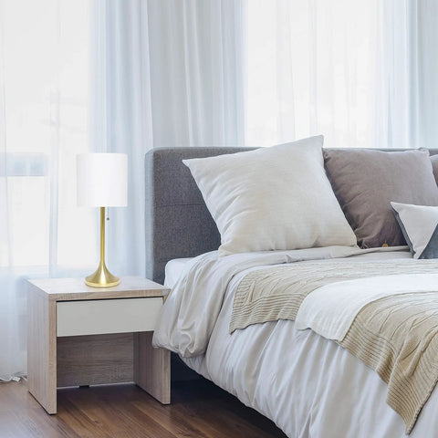 Tapered Fabric Drum Shade Table Lamp In Gold And White With Pull Chain Switch 8 By 8 By 21 Inches on bedside table in bedroom