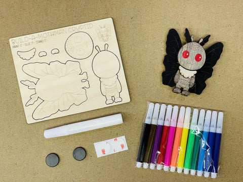 Make Your Own Moth Man Magnet Craft Kit For Kids And Adults with wood pop-out, 12 markers, glue pen, magnets on table