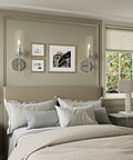 Seasonize Sand Nickle Battery Operated Wall Sconce Set of 2 mounted beside pictures in a cozy bedroom setting.