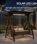 Patio Porch Swing Chair For Two With Canopy Handwoven Wicker Outdoor Glider With Solar LED Light Cushions in garden setting