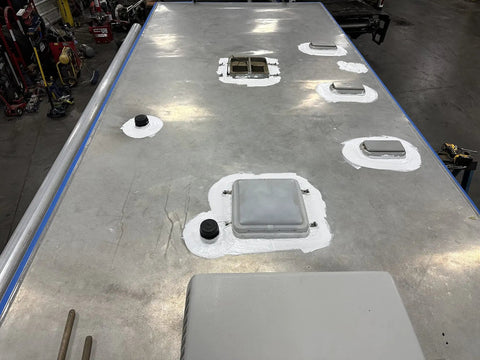 Heavy Duty Silicone Roof Patch Kit 2 Gallon Black applied on RV roof, sealing vents and edges for waterproofing.