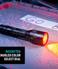 PowerSwitch Dual Color LED Flashlight With Rechargeable Battery And Dual Power Sources, emitting red light on wet surface