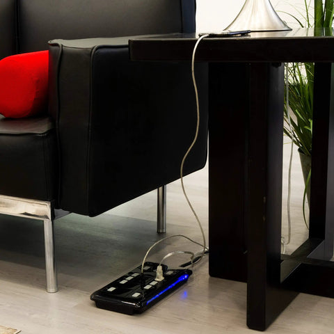 UltraPro 10 Outlet Surge Protector With USB Charging And Two USB Ports 2880 Joules 4 Foot Cord Black placed near sofa