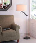 Hydra Adjustable Floor Lamp In Oil Rubbed Bronze Finish With Flexible Arm And Dual Swivel Points 63 Inch Maximum Height 28 Inch Width Casual Modern Style Perfect For Task Lighting Or Ambient Illumination In Living Room Or Office next to a grey armchair