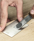 Sharpening a knife with the All In One Credit Card Diamond Sharpening Kit With 180 300 Grit And 600 1000 Grit Stones on wood surface.