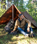 Person sitting under Rip Stop Tarp 8 By 10 Feet Heavy Duty Waterproof Brown Outdoor Shelter For Camping And Backyard Use, Lightweight