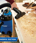 Beast 12 Gallon Wet Dry Vacuum With Detachable Blower, 5 Peak HP, cleaning wood shavings on a workbench, powerful suction shown
