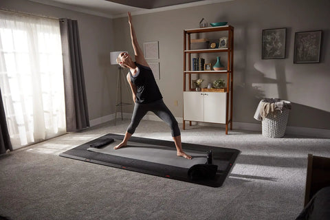 Person practicing yoga on 4x8 Gym Flooring Mat For Peloton Bike Elliptical Treadmill And Home Gym Setup Non Slip Floor Pad