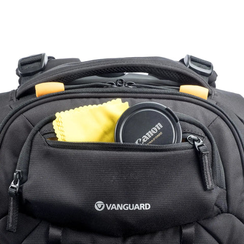 Close-up of front pocket of Eight Wheel Spinner Camera Backpack for DSLRs and Gear with lens cap and cleaning cloth visible.