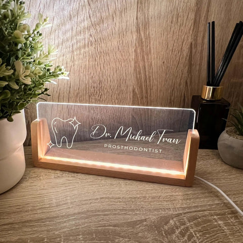 Custom Name And Title Desk Name Plate With LED Light Wood Holder For Dentist Doctor Hygienist Nurse Front Desk Sign Plaque Custom Engraving For Office Decor And Pro Gift on a wooden desk.