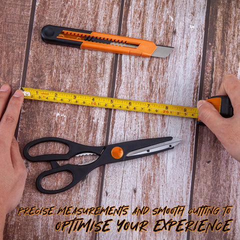Hands using tape measure on wood surface with utility knife and scissors from 39 Piece Home Tool Set With Plastic Toolbox Storage Case Orange For DIY Projects And Everyday Household Repairs Includes Hammer Pliers Screwdrivers Tape Measure And More With Sturdy Heat Treated Chrome Plated Tools