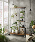 Smooth Rolling 5 Tier Clothes Rack With Industrial Pipe Frame And Rustic Brown Shelves For Organizing Wardrobe Essentials And Flexing Your Daily Fits At Home displaying potted plants in a modern setting.