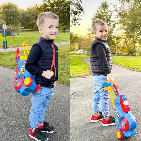 Toddler with upgraded kids golf cart with shoulder strap and putting mat in park, part of toddler golf set with putting mat for 2 3 4 year olds.