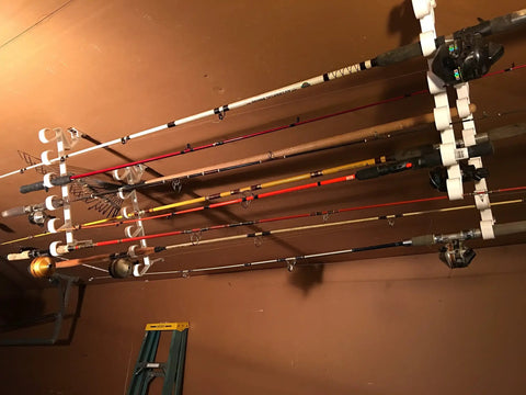 Easy Clip Garage Door Storage Rack With Hooks For Fishing Rods Kayak Paddles And Light Garden Tools Installs In Seconds No Tools Needed Clips To Garage Door Hinge Tubes For Quick No Fuss Organization showing multiple rods stored vertically on garage door.