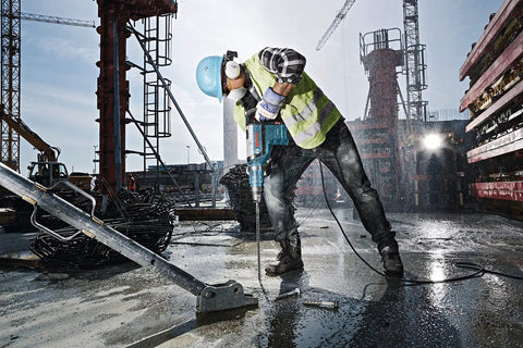 Construction worker using 5/8 in x 24 in x 29 in SDS-Max SpeedXtreme Rotary Hammer Drill Bit on concrete site.