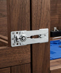Close-up of a long-travel hinge on a wooden frame, part of a Set Of Six Heavy Duty Iron Sectional Couch Connectors For Modular Sofas With Long Travel Hinge And Antislip Finish Rock Solid Hardware Killing Wiggle Room And Keeping Panels Dead Tight.