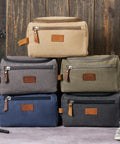 Stack of rugged mountain pattern toiletry bags for men with large capacity, water resistant, canvas Dopp kits in earthy colors.