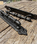 Heavy Duty Cast Iron Door Pull Handles Set Of 2 In Rustic Black With Colonial Victorian Style on wooden surface