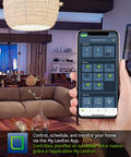 Living room with hand holding smartphone displaying Leviton app, managing Decora Smart WiFi Light Switch With Matter Compatibility.