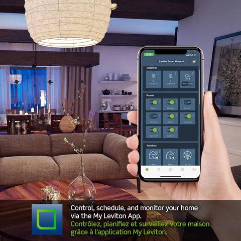 Living room with hand holding smartphone displaying Leviton app, managing Decora Smart WiFi Light Switch With Matter Compatibility.