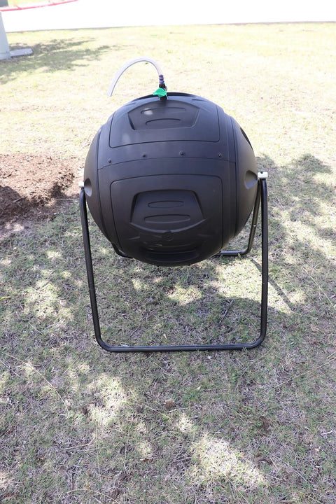 Ms Tumbles 35 Gallon Compost Tumbler With Easy Turn System on lawn, black and green, durable round design, outdoor composting setup