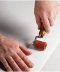 Person applying Extreme White Quick Roof Self Adhesive Roof Membrane Roll 6 Inch By 25 Feet using a small roller tool