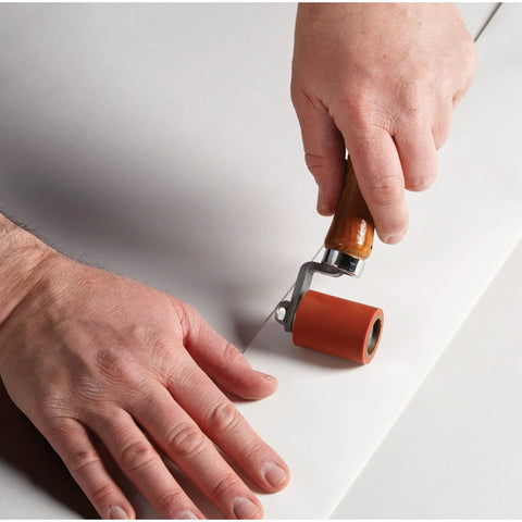Person applying Extreme White Quick Roof Self Adhesive Roof Membrane Roll 6 Inch By 25 Feet using a small roller tool