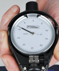Fowler dial bore gauge in black housing with white dial, held in hand; Fowler logo visible.