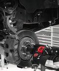 Worker using 1/2 Inch Air Impact Wrench Packin 960 Ft Lbs Of Raw Torque for wheel removal on a vehicle's brake assembly.