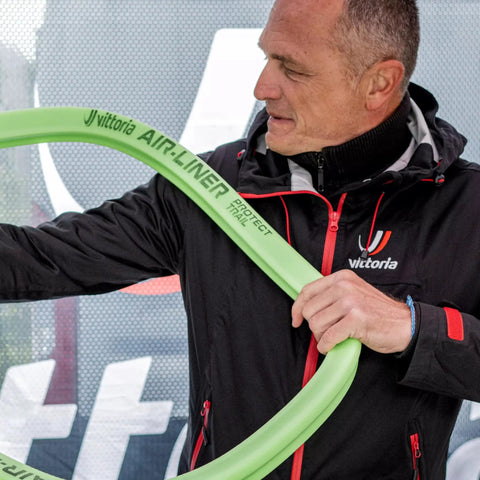 Man holding Air-Liner Protect Trail MTB Tire Insert 29x2.1-2.6, green, lightweight rim protection for trail riders.