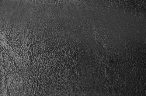 Close-up of thick faux leather PU fabric with soft skin grain in black, ideal for furniture covers and reupholstery, durable and breathable.