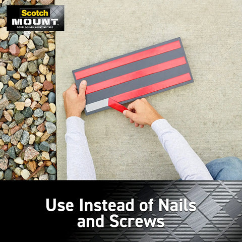 Hands applying Outdoor Mounting Tape Two Roll Pack 1 Inch By 60 Inch Each Holds Up To 15 Lbs on a surface next to rocks.