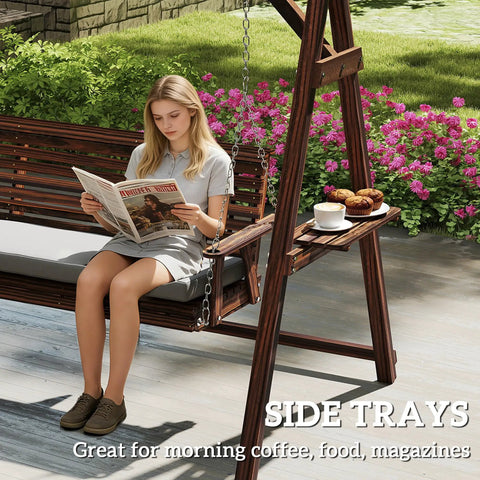 Three Seat Porch Swing With Stand Outdoor Patio Bench For Garden And Poolside Use With Comfy Cushioned Seat Side Trays And Durable Metal Chains Carbonized Brown with a woman reading and using side trays in a garden.