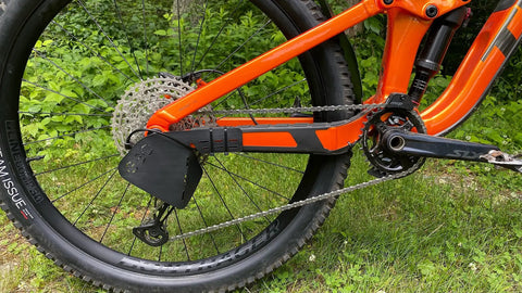 Rear Derailleur Guard For Mountain Bikes And EBikes, Ultra Lightweight And Easy To Install, Universal Fit No Modifications Needed, Protect Your Derailleur From Rocks, Roots And Obstacles On The Trail Made In USA installed on an orange bike