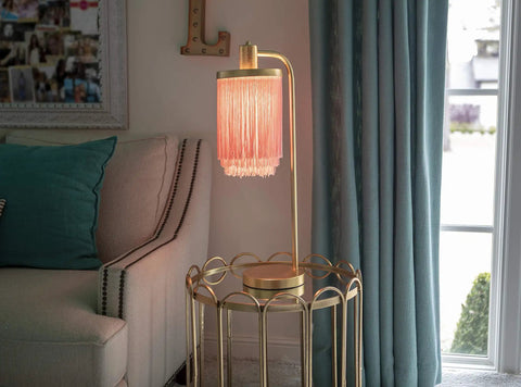 Framboise Fringe Shade Table Lamp With Gold Leaf Finish on a side table next to a sofa, adding elegance to a living room decor.