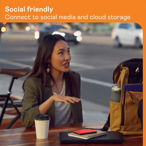 Person sitting at outdoor table with coffee and digital devices, discussing connectivity in social media and cloud storage environment