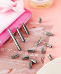 Rock Solid 40 Piece Scrapbook Extension Posts And Screws To Keep Post Bound Album Pages Locked Tight And Looking Fresh Durable Binding Hardware For Photographers And Makers with silver posts on decorative paper.