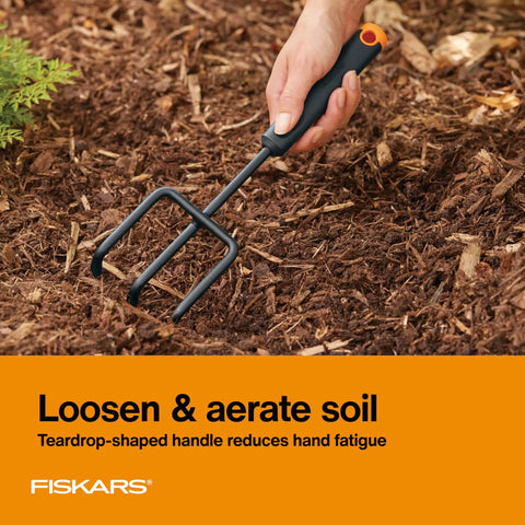 Hand using cultivator from Three Piece Garden Tool Set With Trowel Transplanter And Cultivator Durable Rust Resistant Steel Heads And Ergonomic Handles For Planting Digging And Soil Aeration No Fuss Yard Work in soil