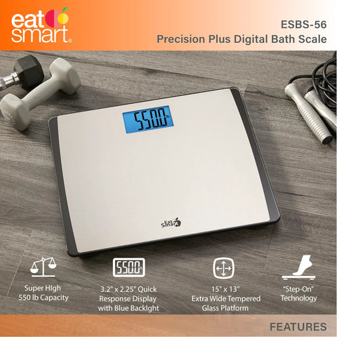 Digital Bathroom Scale 550 Pound Capacity With Extra Wide 15 Inch By 13 Inch Platform Stainless Steel Body Step On Technology Large Backlit LCD Readout Fingerprint Resistant Glass Base on wood floor with dumbbells.
