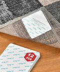 Close-up of 12 Piece Rug Pad Gripper Set with non slip pads and carpet tape anchors on hardwood floor under area rug corner.