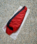 Lightweight Tyvek Tent Footprint Ground Cloth For Camping And Backpacking, breathable tarp under red sleeping bag on gravel.