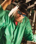 Person wearing Hellraiser Safety Glasses with Light Blue Lenses and Black Frame, UV 99.9% Protection during indoor machining work.