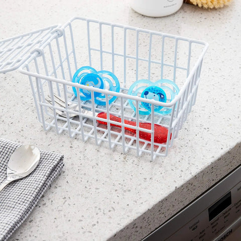 White Coated Steel Cabinet Organizer Basket With Snap Lid holding pacifiers and utensils, durable kitchen storage on countertop.