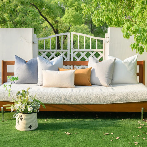 Outdoor bench with assorted cushion covers and a flower basket, showcasing Pack of 4 Outdoor Pillow Covers 18x18 Inches Blue.