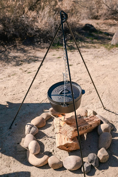 Rugged Heavy Duty Steel Camping Tripod For Open Fire Cooking 43.3 Inch Tall with Dutch oven over campfire in desert setting.