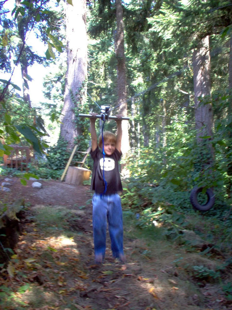 Child using Backyard Zip Line Kit With 200 Feet Of Galvanized Cable And Aluminum Trolley For Epic Backyard Thrills Heavy Duty