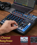 Person adjusting controls on Eight Channel DJ Audio Mixer With Bluetooth Streaming USB Audio Interface DSP FX Mic And Stereo Line Inputs Wireless Song Sync From Phone Gig Ready For Home Studio Mobile Gigs And Party Setups. Laptop and headphones visible.
