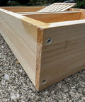 Corner view of a screw-constructed bee hive top feeder made from premium pine wood, highlighting durability for langstroth beekeeping gear.