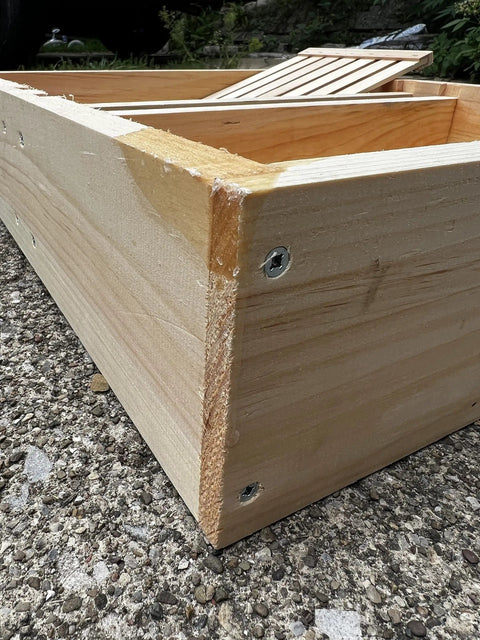 Corner view of a screw-constructed bee hive top feeder made from premium pine wood, highlighting durability for langstroth beekeeping gear.